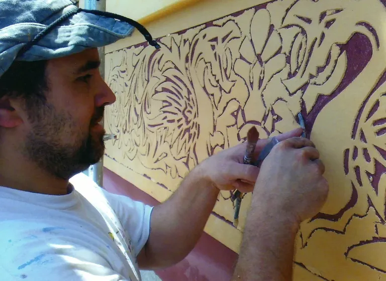 Xavi applying stucco to a wall