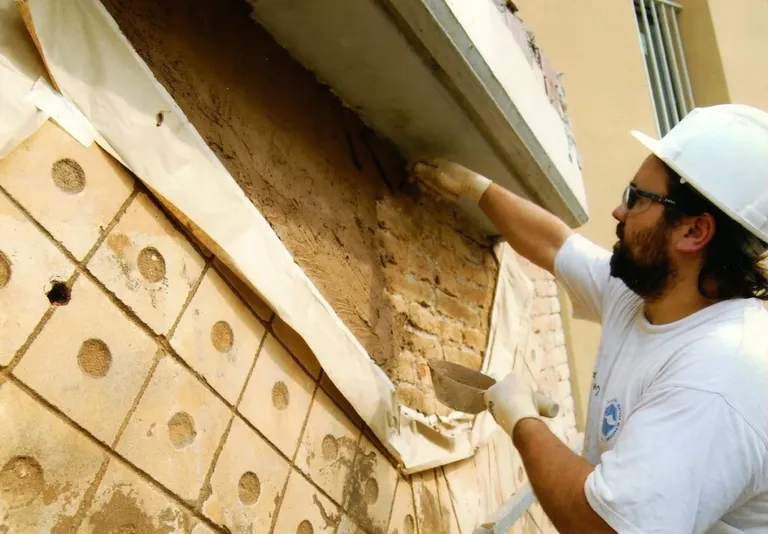 Xavi applying stucco to a wall